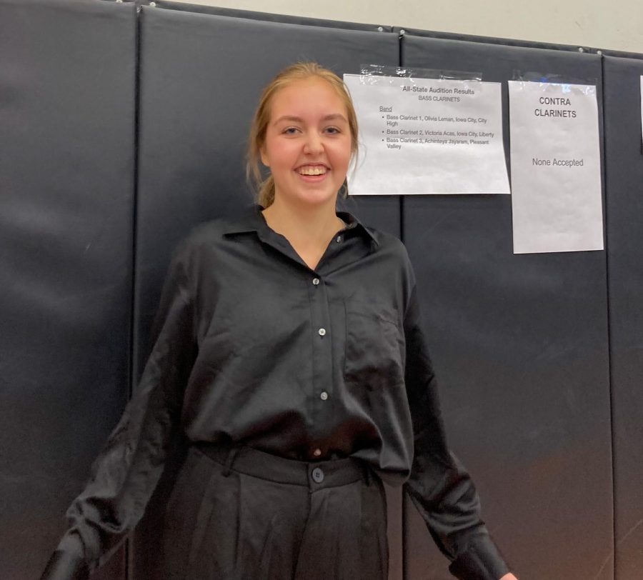 Liv Leman 25 poses next to the list of accepted bass clarinets