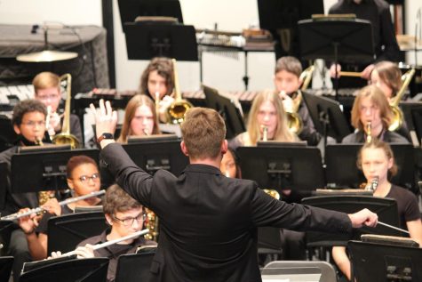 Student teacher Phil Bueche conducts during the winter band concert