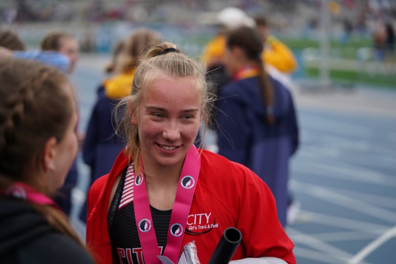 Freshman Ani Wedemeyer talking with the other three members of 4x400 relay., State Track, 2022 (The quartet placed first running 3:52.72)