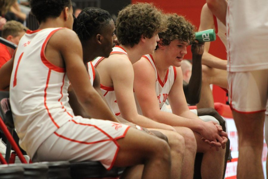 Evan Lampe 23, Thomas Ksobiech 23, Shamar Benton 23, and Trey Wright 25 listen to their coach during a timeout. 