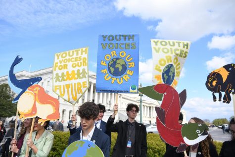 Students hold signs advocating for climate education legislation outside the US Capital.