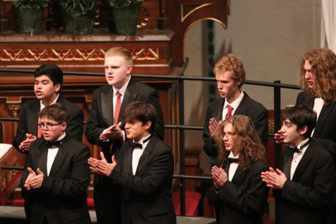 Members of Männerchor clap their hands during their second piece of the night at the annual Choir Cathedral Concert