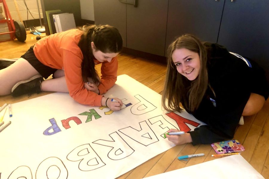 Co-Yearbook Editors Lili Moessner 24 and Megan Swartzendruber 25 work on a Yearbook Pickup sign.