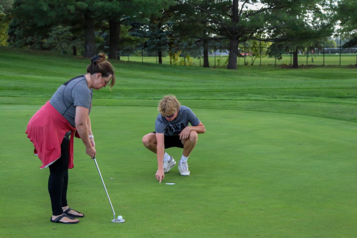 Nick Meredith 25 lines up his mothers putt at Pleasant Valley Golf Course.