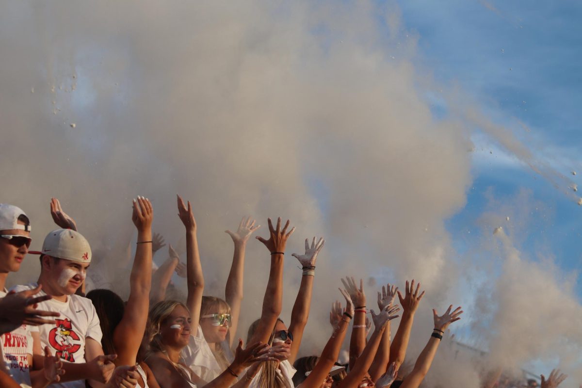 The student section throws up baby powder to celebrate kickoff at the white-out themed game