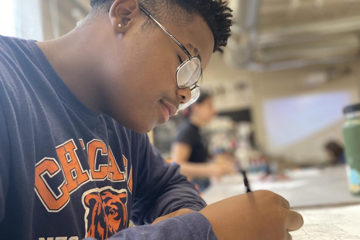 Jeremiah Lowe working on a two-point perspective piece in Black and White drawing after shattering ligaments in his knee, ending his football career