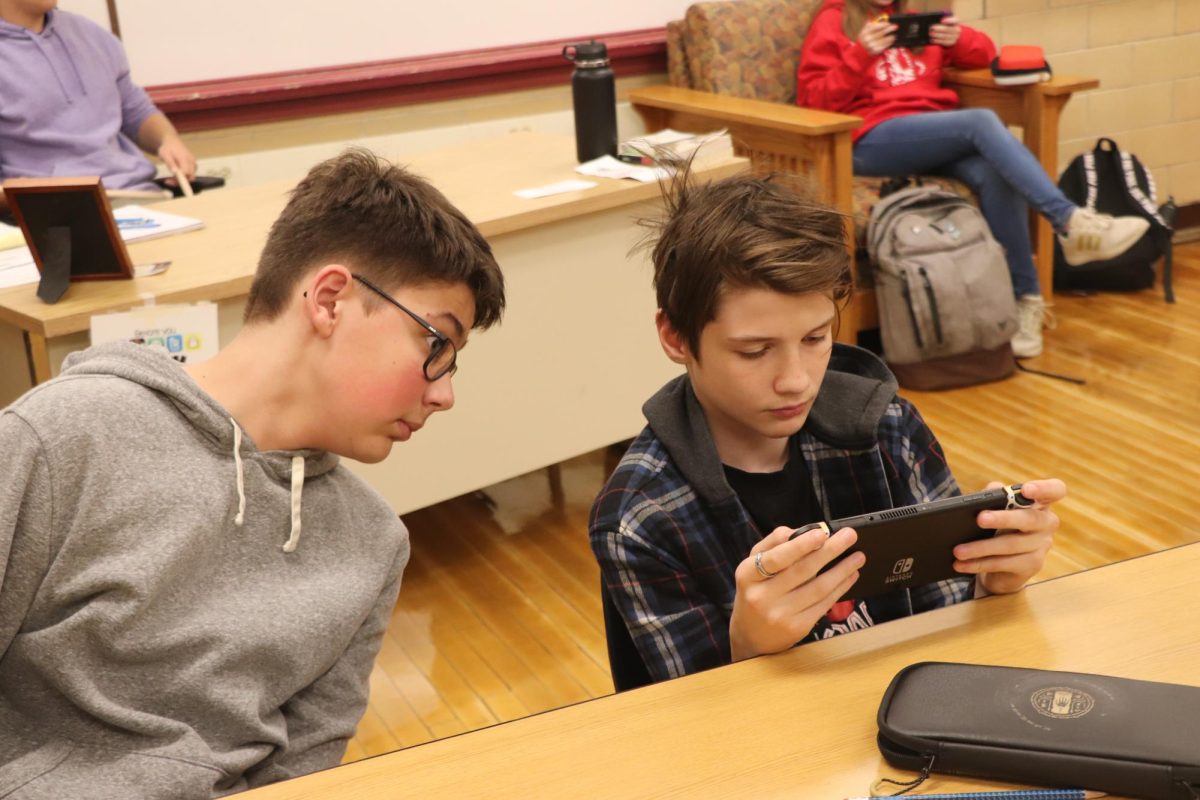 Kaden Huntley ‘25 and a friend look at a Nintendo Switch