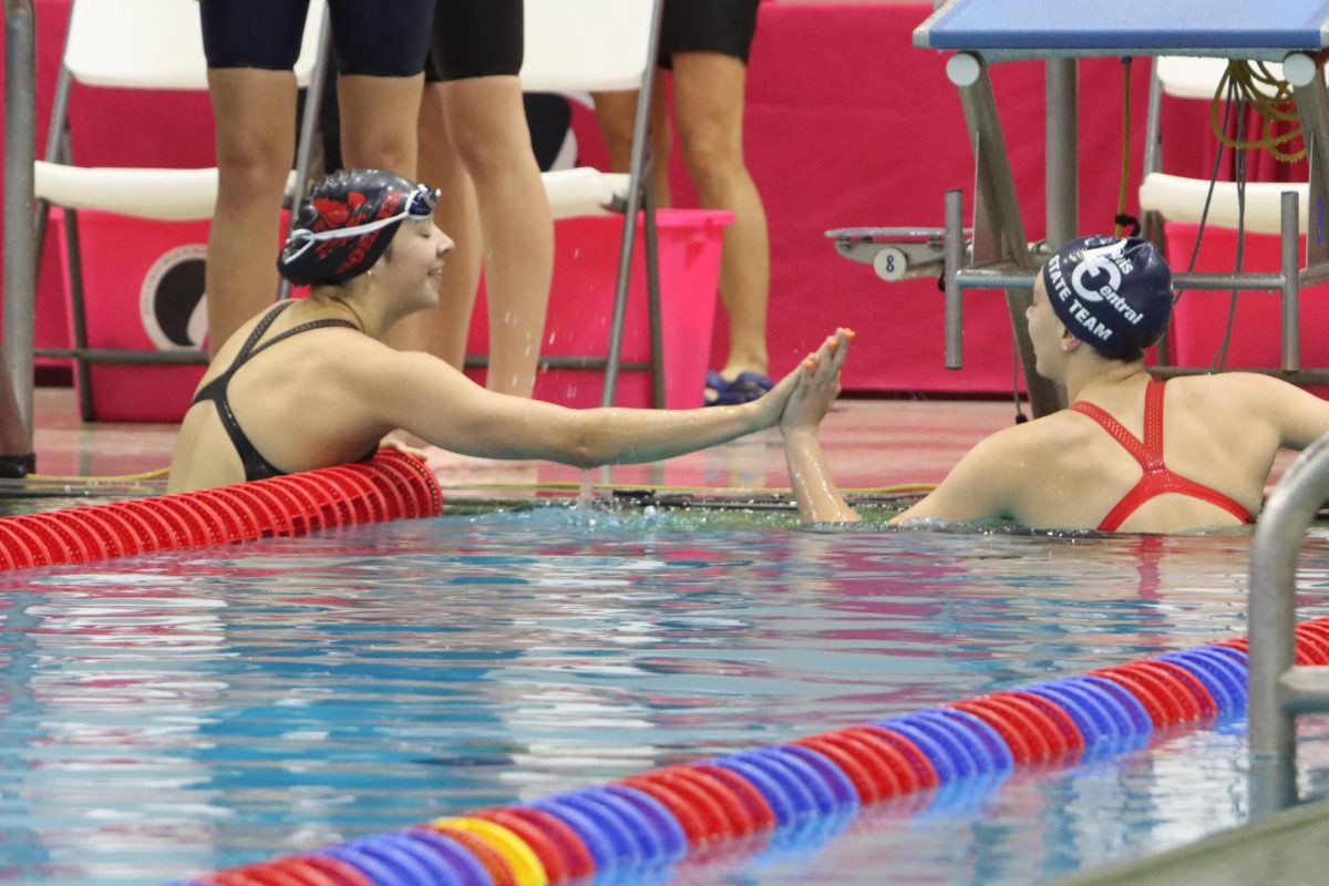 Grace Hoeper 25 reaches across lanes to high-five a competitor during the 4x100Y Relay