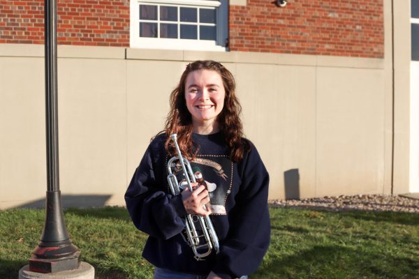 Jillian Leman 26 stands outside of City High’s music wing with her trumpet