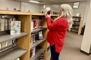 Librarian Jenahlee Chamberlain returns books to City High shelves after injunction on book bans