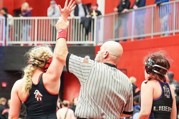 Molly Carlson gets her arm raised after winning against an opponent from Liberty. Photo courtesy of Molly Carlson
