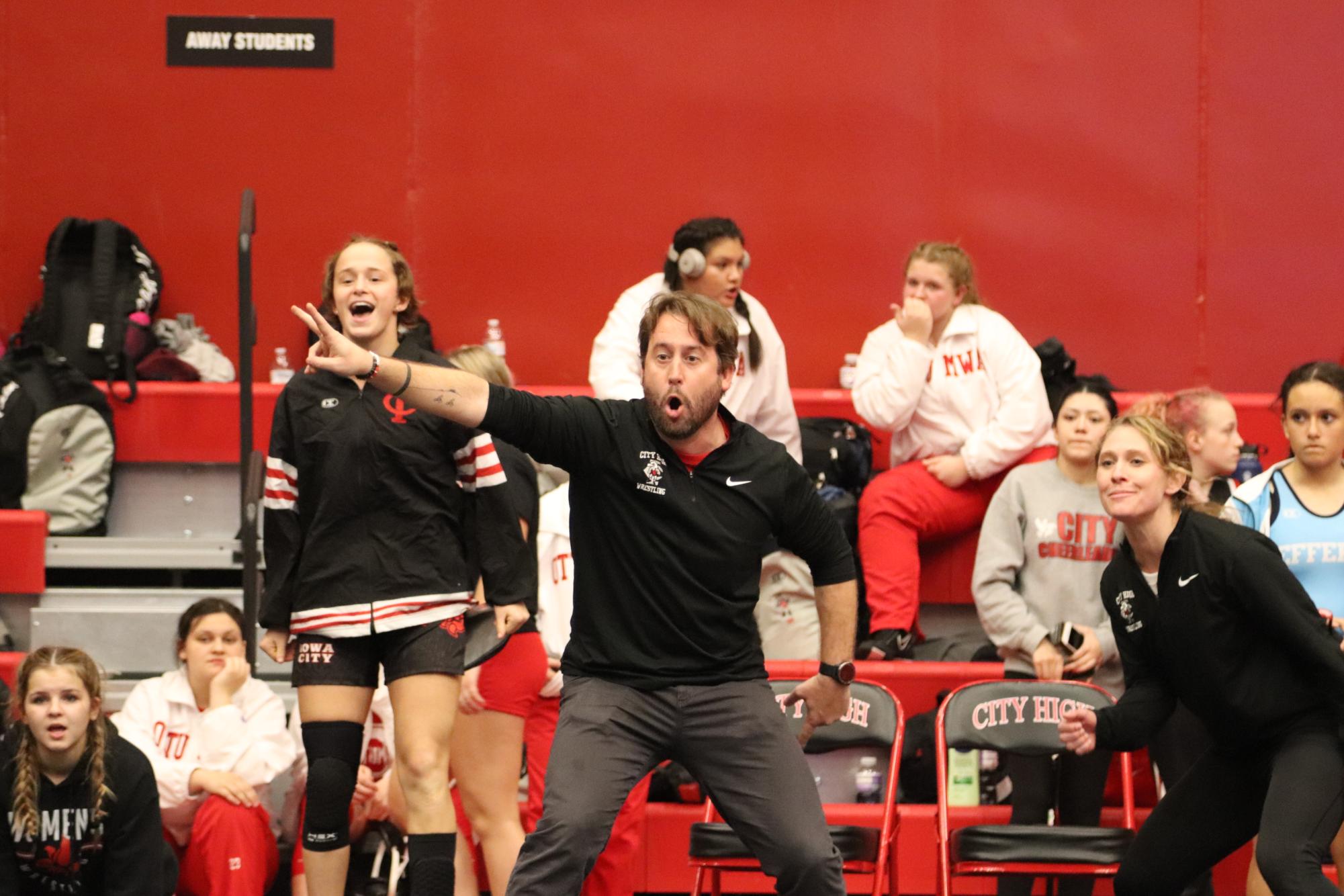Women’s Wrestling Head Coach Ryan Ahlers yells out to his wrestler on the mat during the Little Hawk home tournament