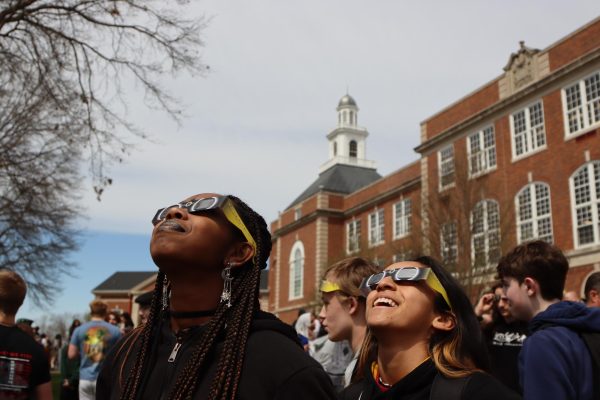 Dominique Blackman 24 and Maria Henderson 25 look up at the solar eclipse in front of City High School, on April 8, 2024.