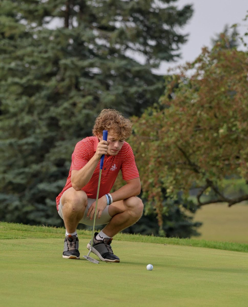 Del Brewer '27 has a shot at birdie, crouching down to line up his ball with the hole. After asking Del about how he felt his putting game was during the meet, he said, "It could've been better, could've sunk more putts but that's golf".
