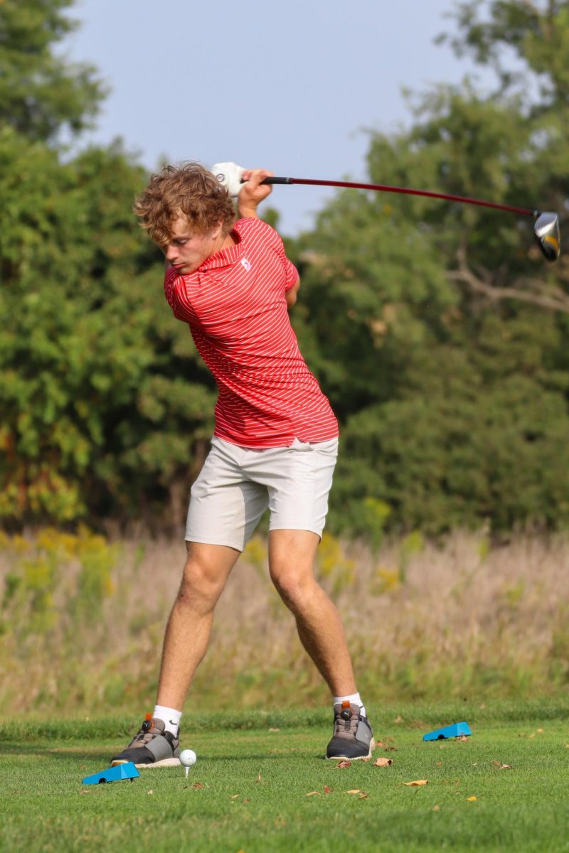 Del Brewer '27 reaches back and unleashes to drive the ball straight down the fairway on hole 7. The wind was a large factor that players needed to consider during the meet, causing many to try and keep their shots low and out of the wind.