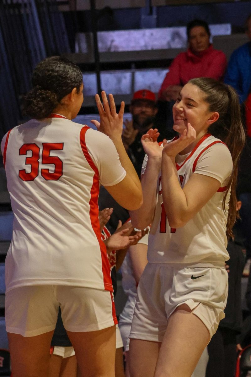 Hattie Galloway and Halle Larew have some fun in the handshake line before the game.