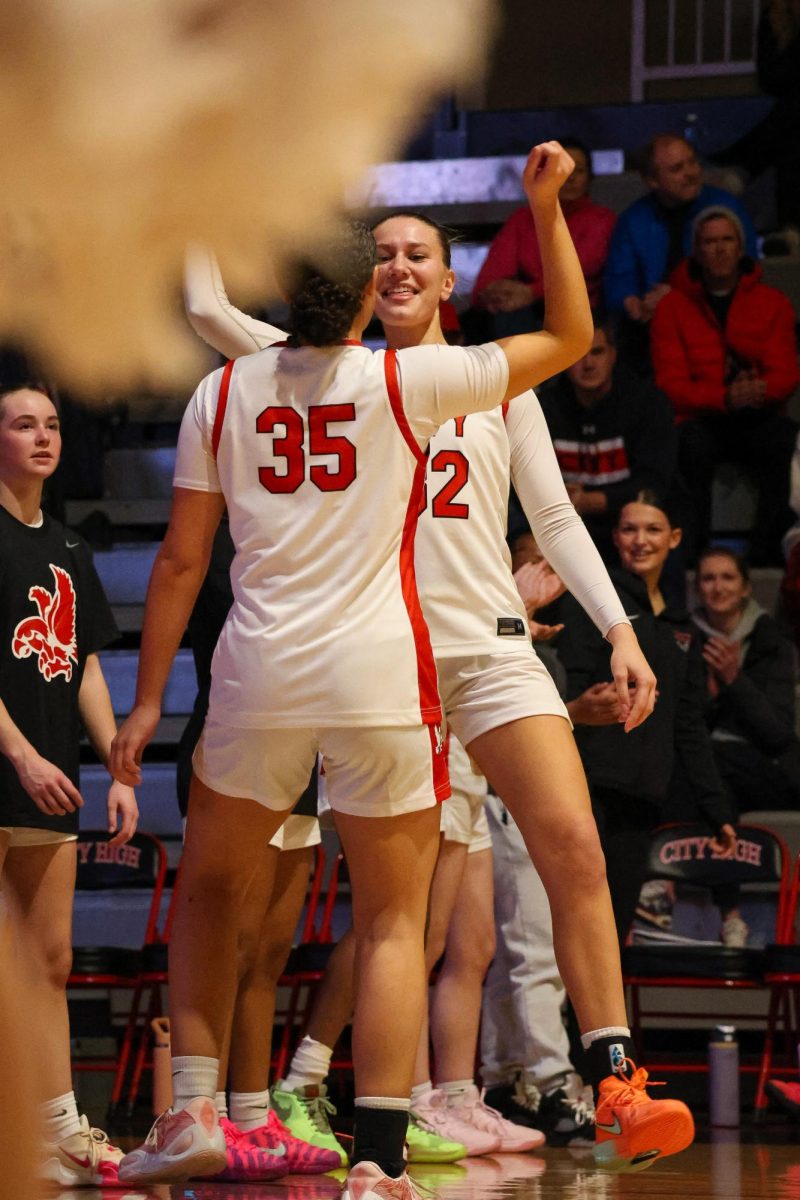 Thisbe Lewis and Halle Larew dance in the handshake line before the game.