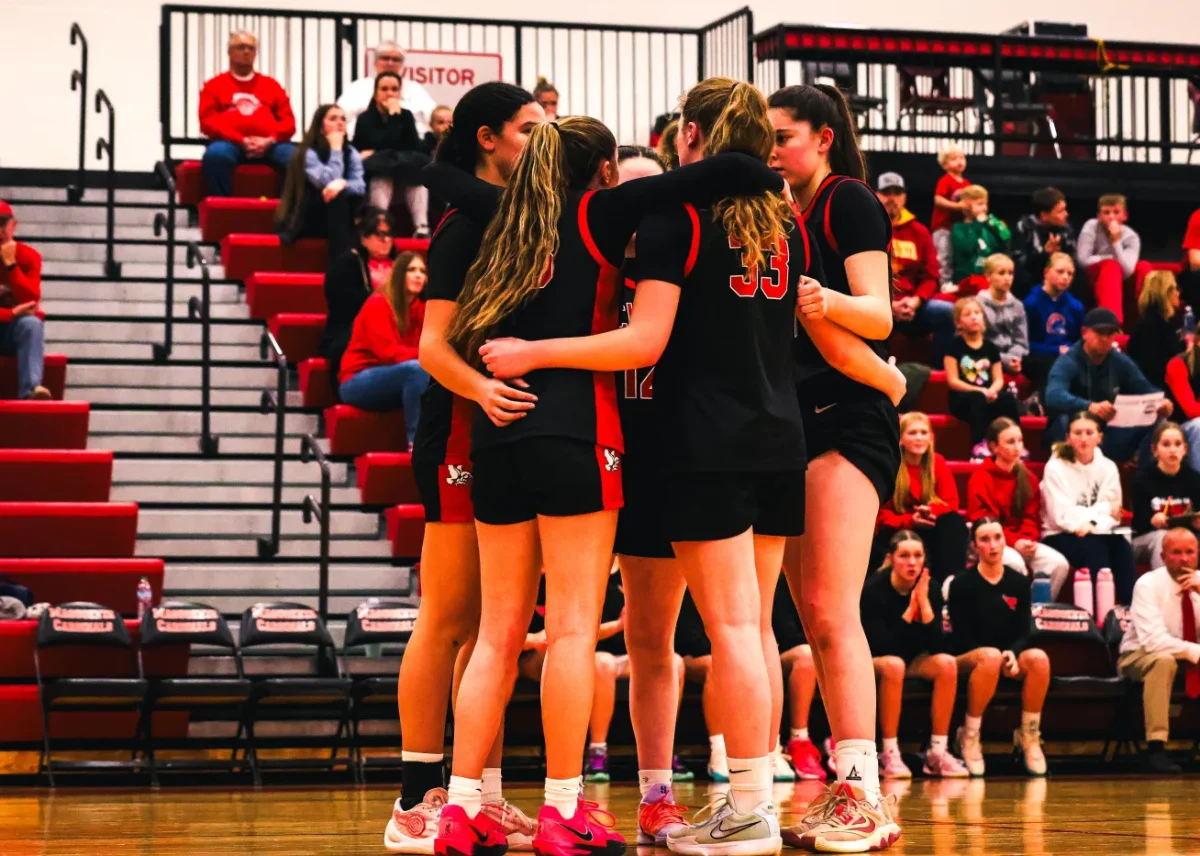 The Little Hawks girls basketball team huddles up to discuss during their game against Maquoketa. The Little Hawks went on to win the game 36-34. 