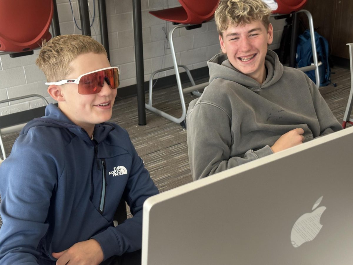 Jack Litton and Henry Birt work on the 2026 Red and White yearbook.  They finished their "Friday Interviews" and are adding "Don't Blink" moments to the portrait pages.