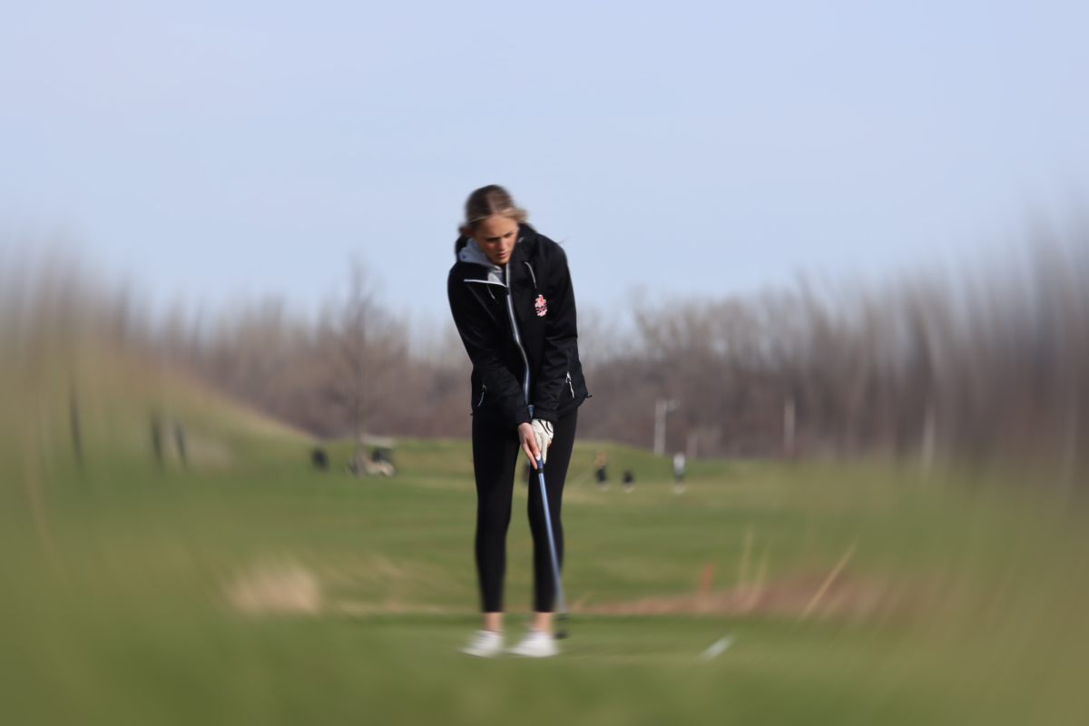 Libbie Hicks '27 chips the ball onto the green at Pleasant Valley Golf Course.